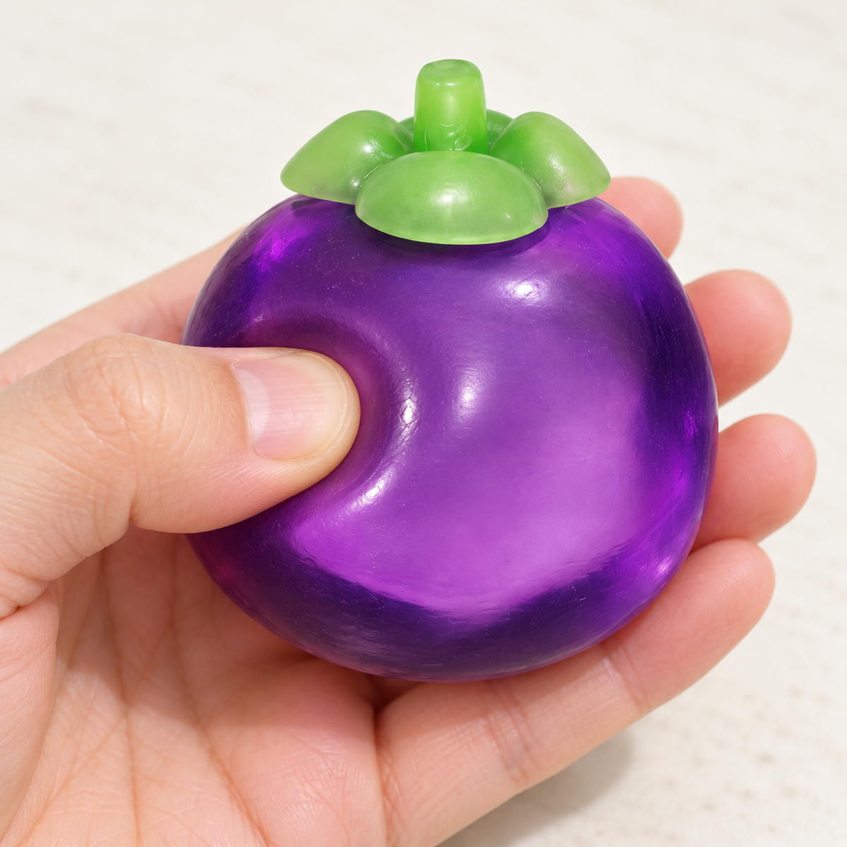 Purple Mangosteen Squishy Toy with a Green Leaf Top · mproduct-bee9e580eb2a959ef8e5